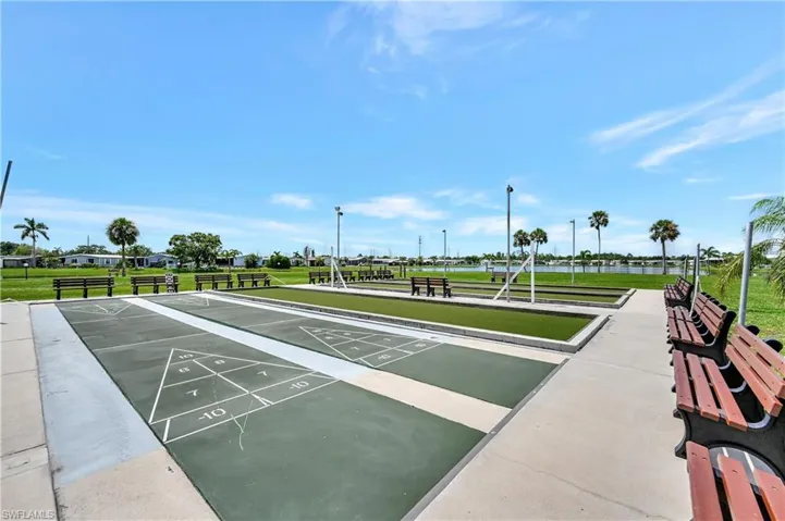 View of community featuring a yard and shuffleboard