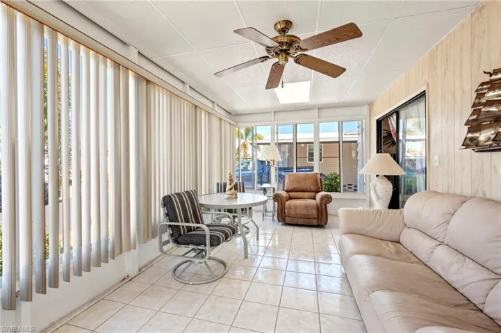Sunroom / solarium featuring tile patterned flooring, plenty of natural light, and wooden walls