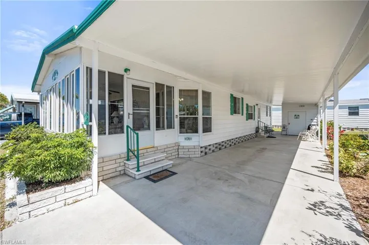 View of patio with a carport, entry steps, and a sunroom