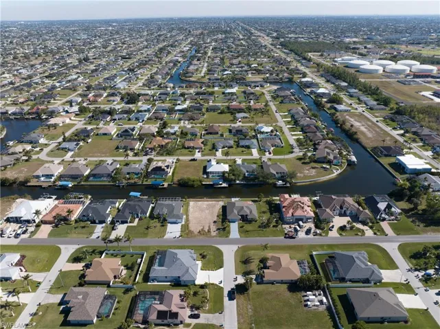 Aerial view of property and surrounding area featuring nearby suburban area and a large body of water