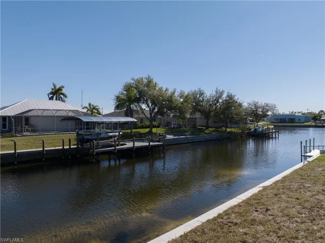 Dock area with a water view and a yard