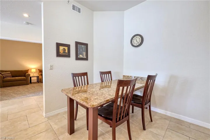 Dining space featuring a textured wall, light tile patterned floors, and a textured ceiling