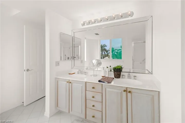 Master Bathroom featuring double vanity, light tile patterned floors, and a shower stall
