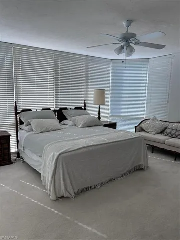 Bedroom featuring carpet floors, ceiling fan, and a textured ceiling