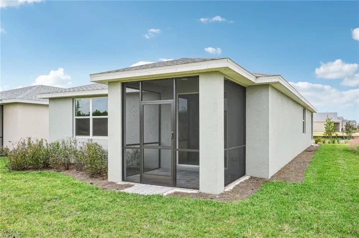 View of side of property with a lawn and a sunroom