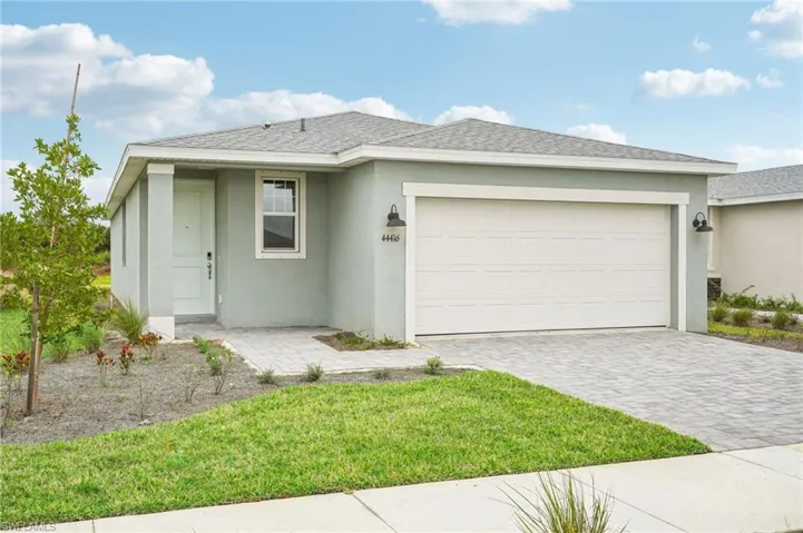 View of front of home with a garage and a front lawn