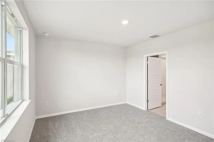 Empty room featuring light colored carpet