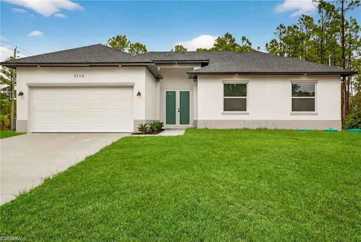 Prairie-style house with an attached garage, stucco siding, and a front lawn
