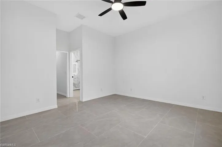 Spare room with a ceiling fan and baseboards