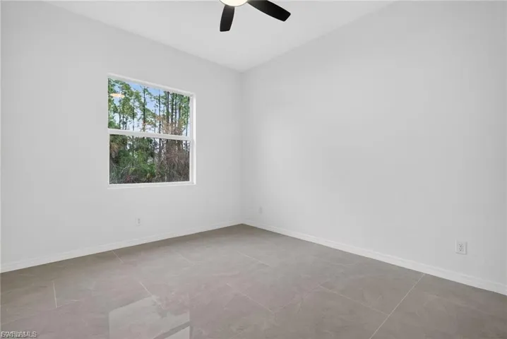 Unfurnished room featuring baseboards and ceiling fan