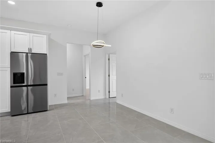 Unfurnished dining area featuring baseboards and light tile patterned flooring