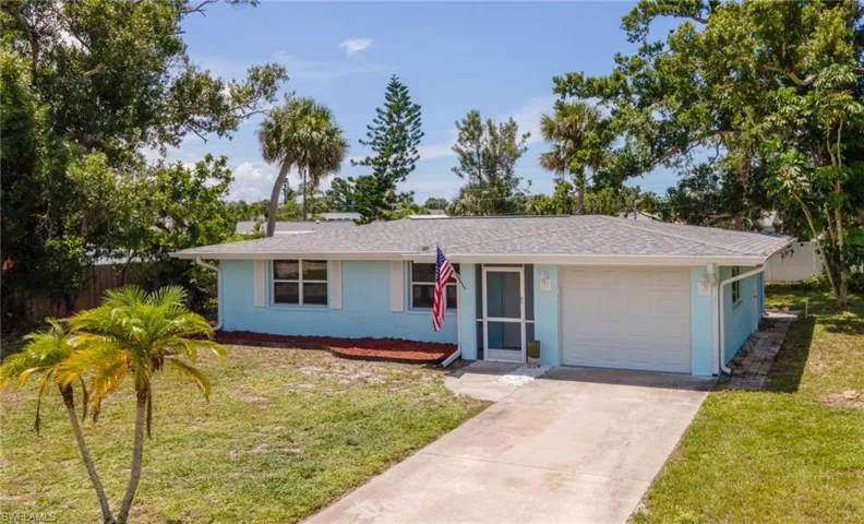 Ranch-style house with a garage, stucco siding, a front lawn, and concrete driveway
