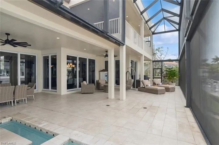 View of patio / terrace featuring a balcony, ceiling fan, an outdoor hangout area, a lanai, and a pool