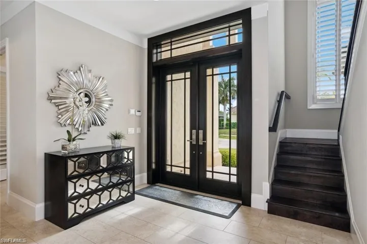 Entryway with stairs, french doors, and baseboards