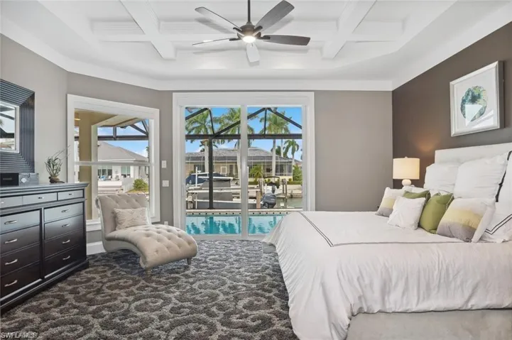 Bedroom with carpet floors, access to outside, coffered ceiling, and beamed ceiling