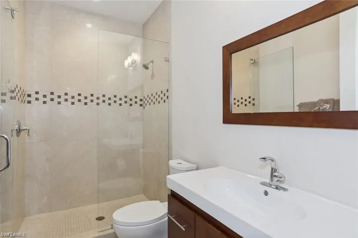 # 3 Bathroom upper level featuring toilet, a shower stall, and vanity