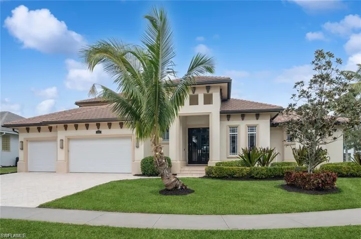 View of front facade with a garage, decorative driveway, a front lawn, and stucco siding