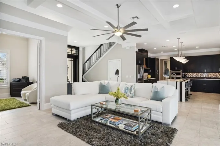 Living room with recessed lighting, beam ceiling, visible vents, and stairway