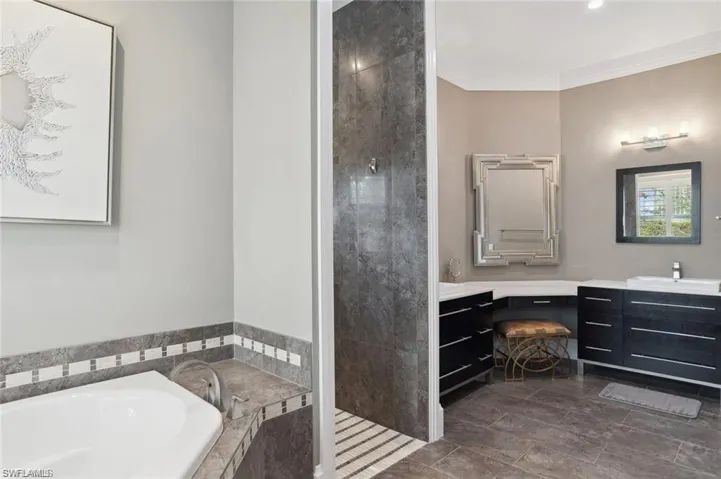 Bathroom with a tile shower, crown molding, vanity, and a bath