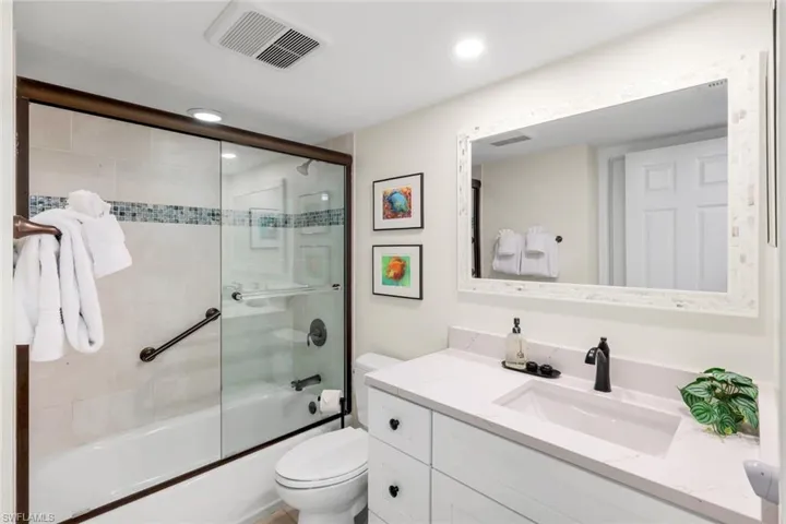 Full bathroom featuring bath / shower combo with glass door, vanity, and recessed lighting