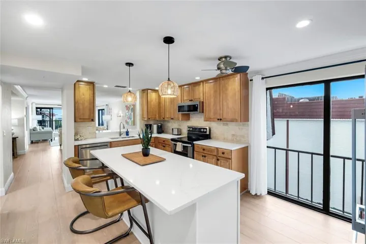 Kitchen featuring brown cabinets, hanging light fixtures, appliances with stainless steel finishes, backsplash, and recessed lighting