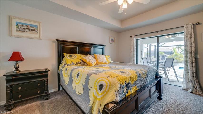 Master bedroom has coffered ceiling and sliders out to the lanai and pool area!