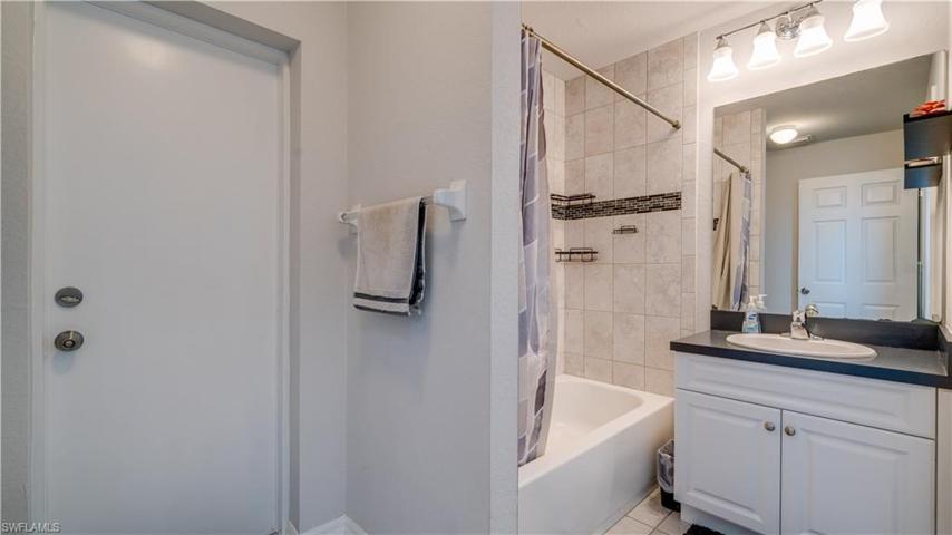 Guest bathroom located in back hall accessible to guest quarters, and door out to the lanai & pool area.