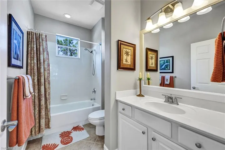 Full bathroom featuring tile flooring, vanity, toilet, and shower / bath combo