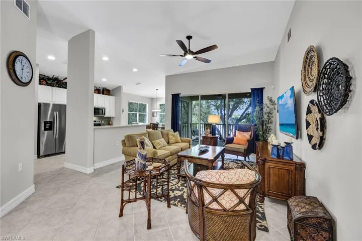 Living room with ceiling fan and light tile flooring