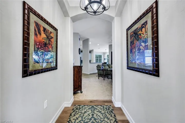 Hallway featuring a chandelier and tile flooring