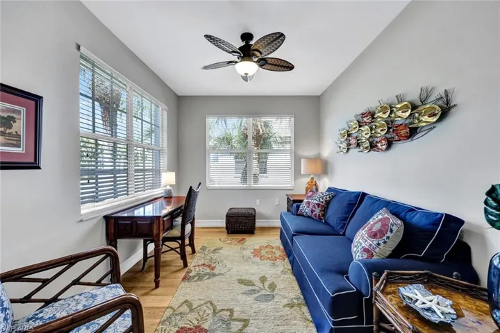 Living room with ceiling fan and light hardwood / wood-style flooring