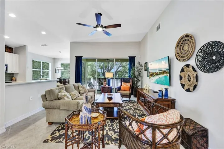 Tiled living room with plenty of natural light and ceiling fan