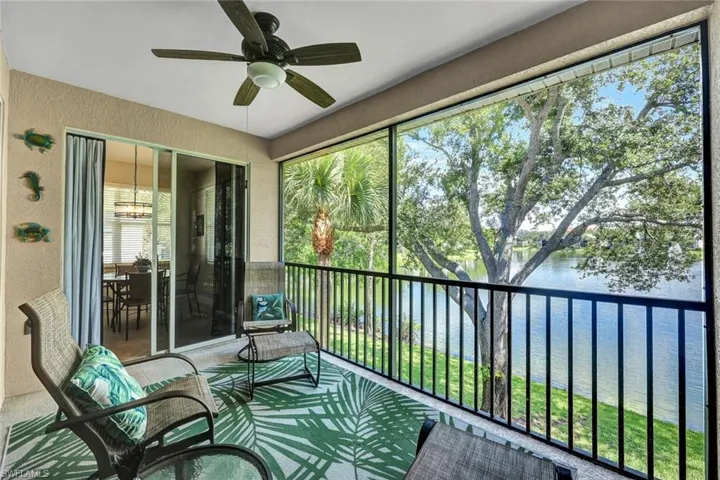 Sunroom / solarium featuring ceiling fan and a water view