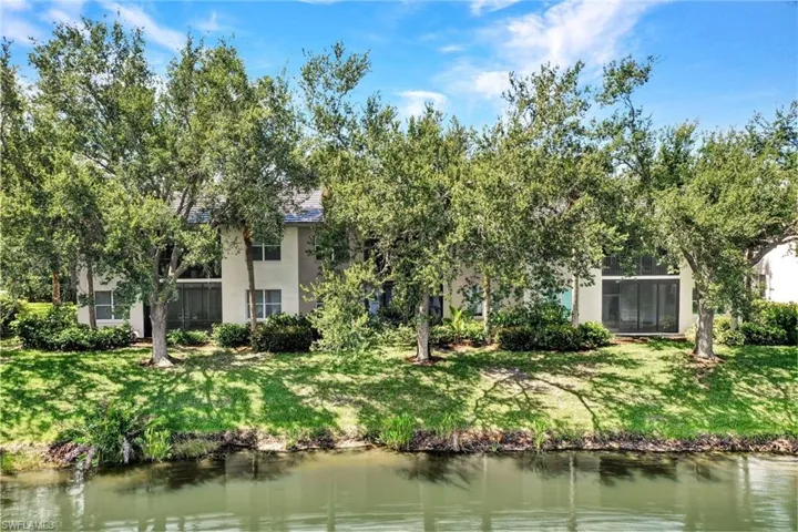 Rear view of property featuring a water view and a yard