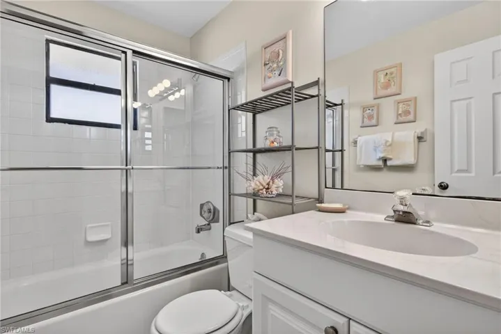 Bathroom featuring vanity and shower / bath combination with glass door