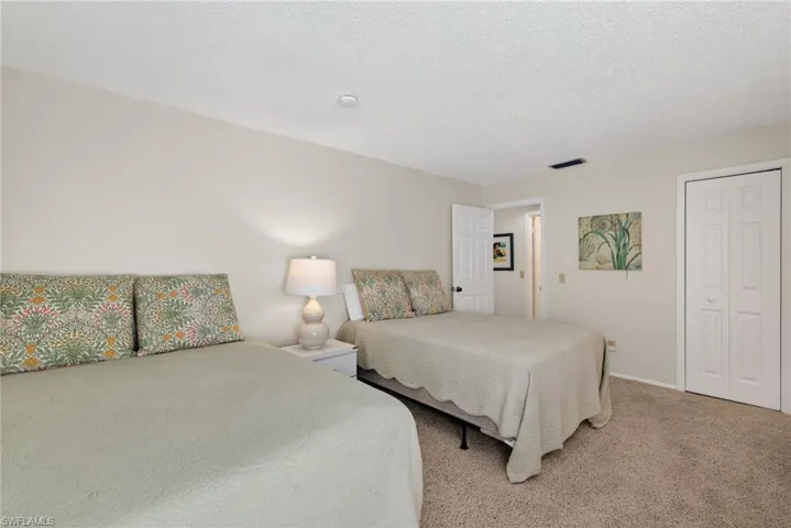 Bedroom with carpet flooring, a textured ceiling, and a closet