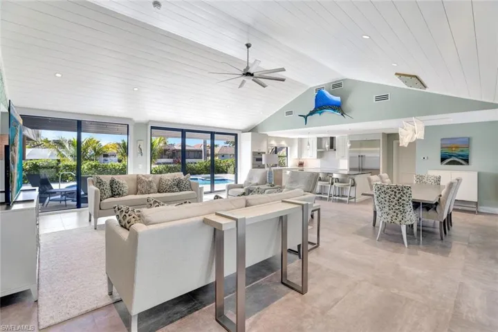 Living room with ceiling fan, wooden ceiling, and high vaulted ceiling
