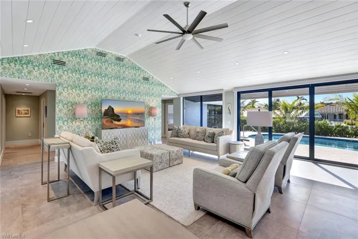 Living room featuring ceiling fan, wood ceiling, and lofted ceiling