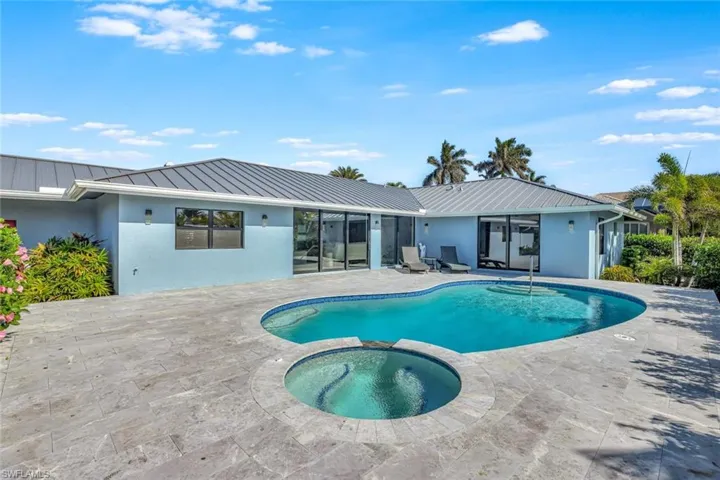 View of pool with an in ground hot tub and a patio