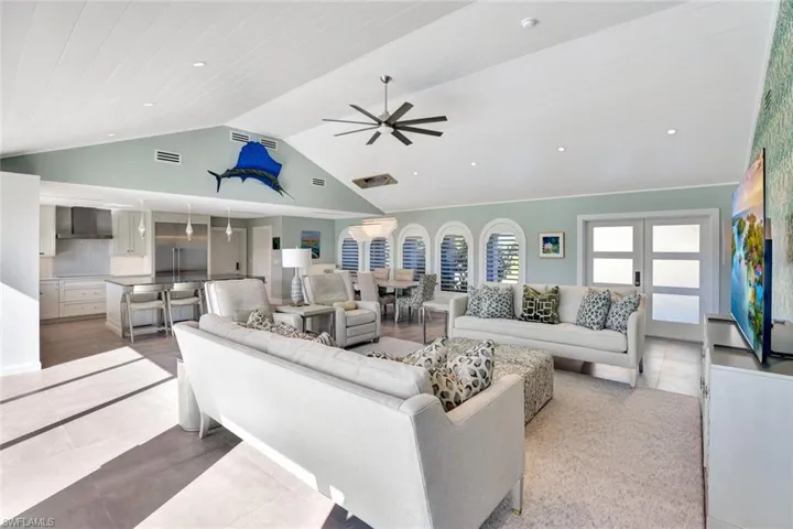 Tiled living room with ceiling fan, french doors, high vaulted ceiling, and wood ceiling