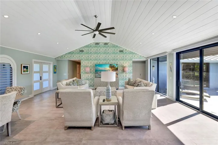Living room with vaulted ceiling, ceiling fan, and wood ceiling