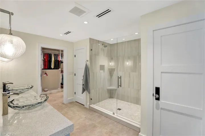 Bathroom featuring tile patterned floors and a shower with shower door