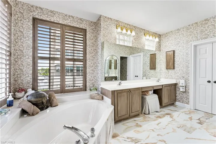 Ensuite primary bath has dual vanities, dressing area, private water closet.