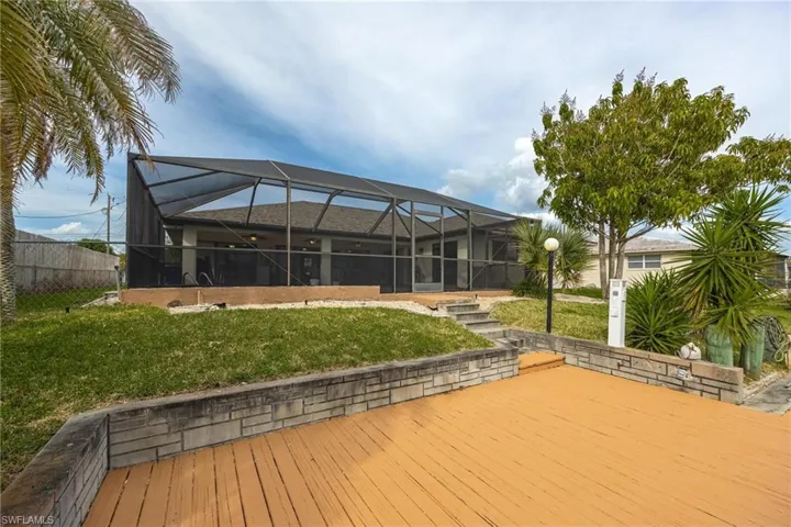 Deck featuring a sunroom, glass enclosure, and a fenced backyard