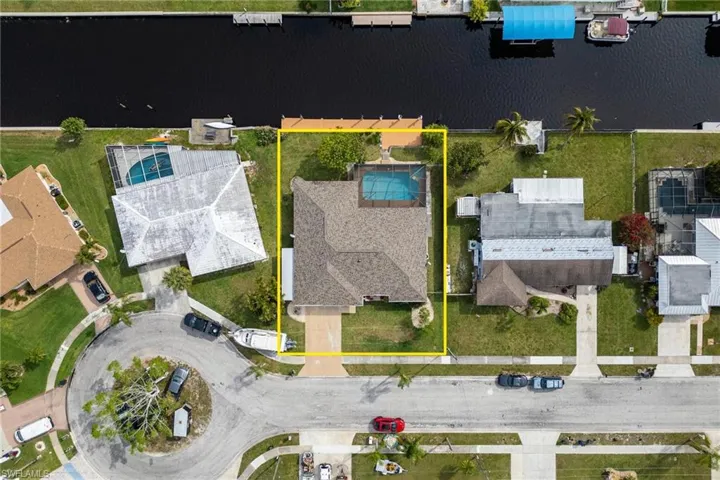 Aerial perspective of suburban area featuring property boundaries highlighted and a large body of water