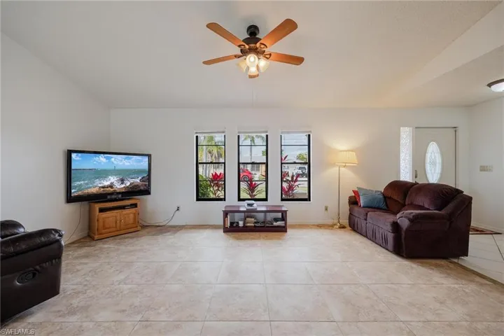 Living area featuring a ceiling fan and light tile patterned floors