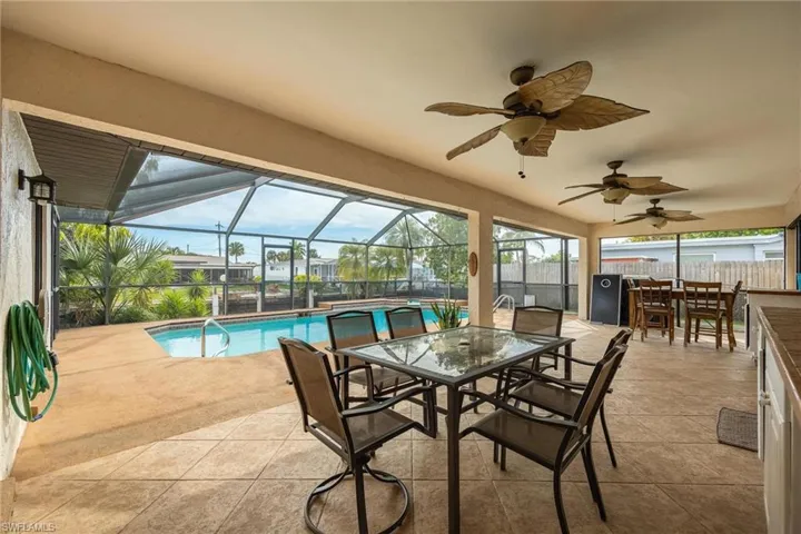 Sunroom featuring outdoor dining space, a patio, and a ceiling fan