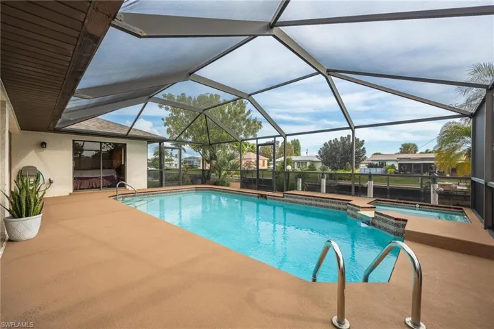 Combined pool / hot tub with a sunroom, a lanai, and a patio