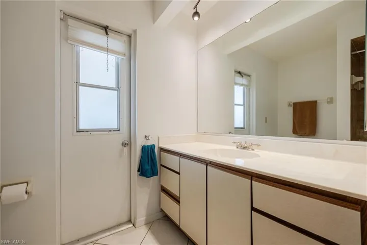 Full bath featuring vanity and light tile patterned flooring