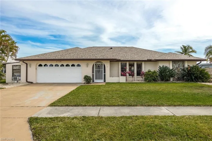 Single story home featuring stucco siding, a front lawn, a garage, driveway, and a shingled roof